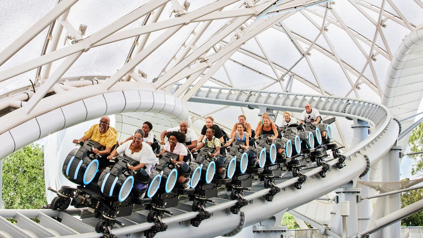 Guests riding TRON Lightcycle Run under its white canopy